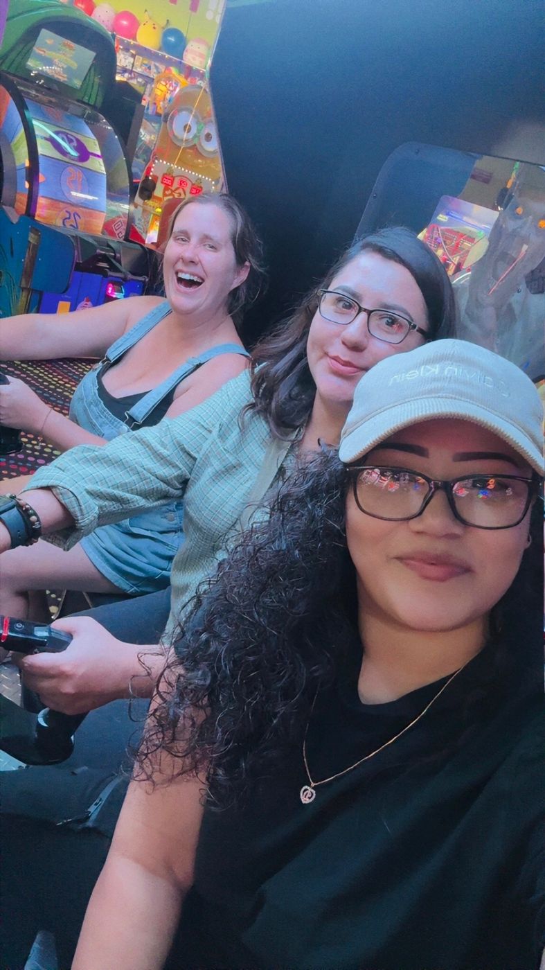 Three members of the Big Moves family laughing together at an arcade