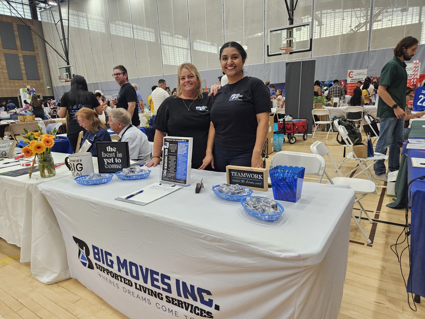 Two Big Moves staff members at the Big Moves Inc. booth during a community resource fair